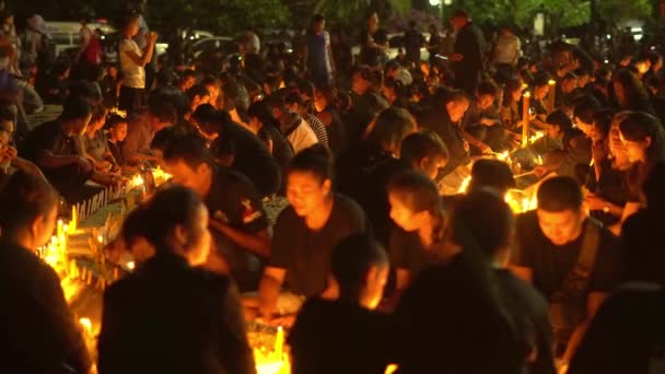 Verscheidene duizend bewoners en toeristen gekleed in zwarte kleding verzamelden zich voor het Saphan Hin heiligdom voor een ceremonie van kaarslicht aan respect betuigen aan de koning Bhumibol Rama 9. — Stockvideo