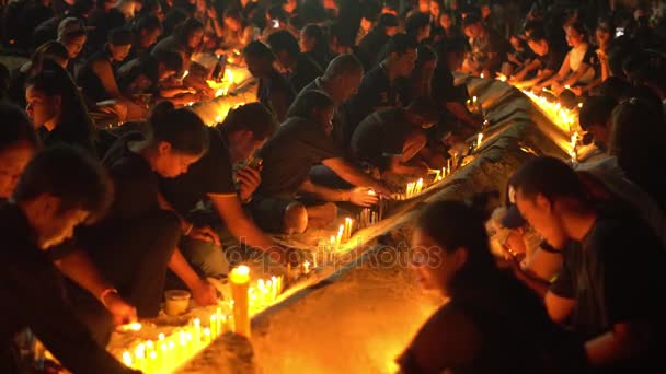 Verscheidene duizend bewoners en toeristen gekleed in zwarte kleding verzamelden zich voor het Saphan Hin heiligdom voor een ceremonie van kaarslicht aan respect betuigen aan de koning Bhumibol Rama 9. — Stockvideo