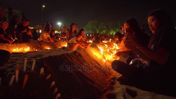 Vários milhares de residentes e turistas vestidos com trajes pretos se reuniram em frente ao santuário Saphan Hin para uma cerimônia à luz de velas para pagar respeito ao rei Bhumibol Rama 9 . — Vídeo de Stock