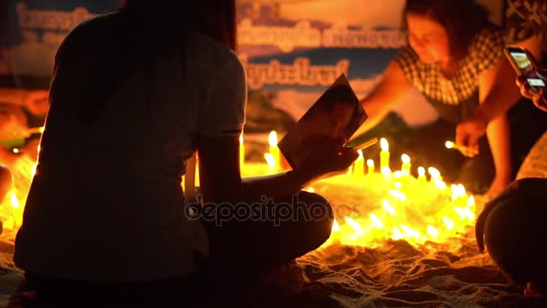Азиатские свечи на песке в религиозной церемонии, ветрено. Медленное движение — стоковое видео