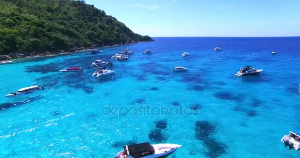 Пляж Рача Айленд. Таиланд, Пхукет. Яхты, катамараны и лодки, плывущие в кристально чистой голубой воде океана. Летает от пляжа к океану. Вид с воздуха. 4K . — стоковое видео