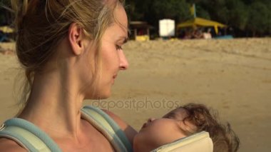 Genç anne uyuyan bebeği günbatımı ışık Hemşirelik. Ağır çekim