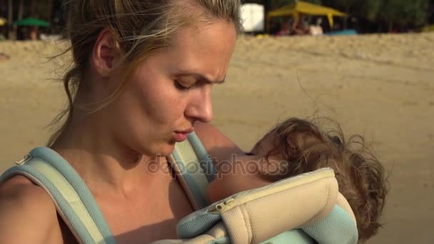 Νεαρή μαμά Νοσηλευτική το μωρό στον ύπνο της στο φως του ηλιοβασιλέματος. Αργή κίνηση — Αρχείο Βίντεο