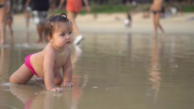 Sahilde oturan ve dalgalar zevk şirin bebek