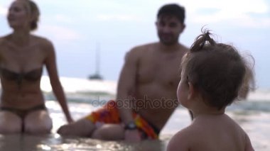 Mutlu bir aile deniz kıyısında yürüyüş. Ağır çekim