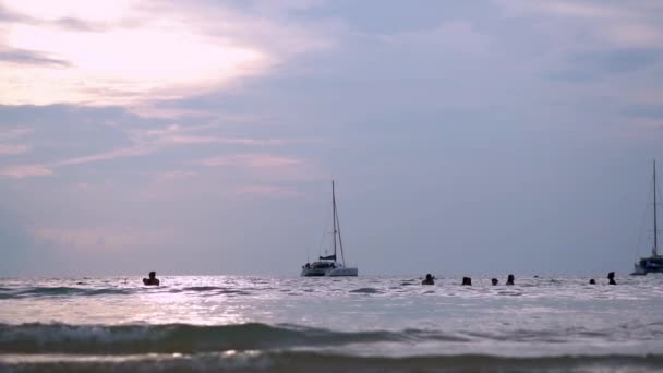 Die sonne geht auf über einem schönen strand in thailand, während wellen durch den sand spülen. — Stockvideo