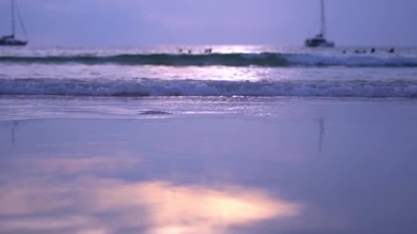 De zon stijgt boven een prachtig strand in Thailand als golven over het zand wassen. — Stockvideo