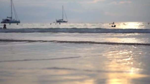 De zon stijgt boven een prachtig strand in Thailand als golven over het zand wassen. — Stockvideo