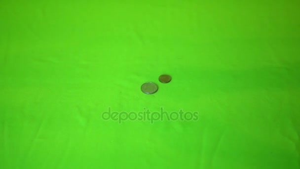 Mynt som faller på en grön bakgrund, Slowmotion — Stockvideo
