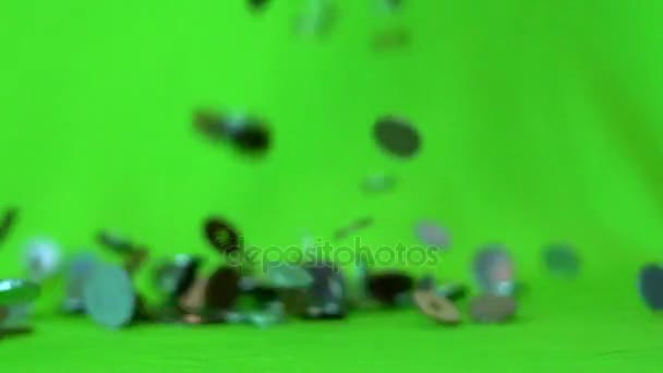 Coins falling on a green background, slow motion — Stock Video