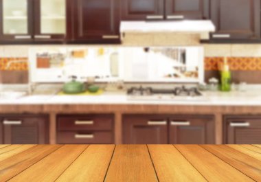 Wood table top on blur the background of the kitchen. - can be used for display your products or promotional and advertising posters clipart