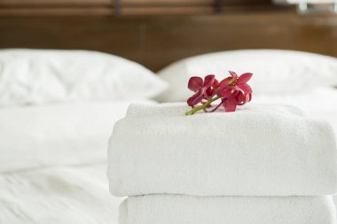 Yakın çekim, taze havlu otel odasının içine yerleştirilen çiçekler.