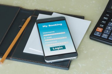 Online rezervasyon uygulamaları ile masada telefon akıllı telefon.