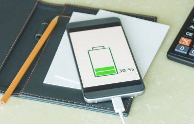 Ahşap masanın üzerinde şarj mobil akıllı telefonlar