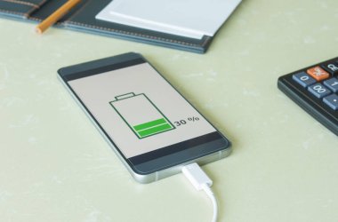 Ahşap masanın üzerinde şarj mobil akıllı telefonlar