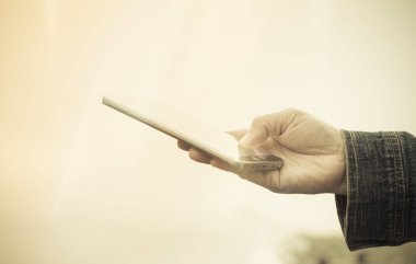 Mobil akıllı telefon açık kullanarak bir insan yakın. Vintage tarzı. Seçici odak.