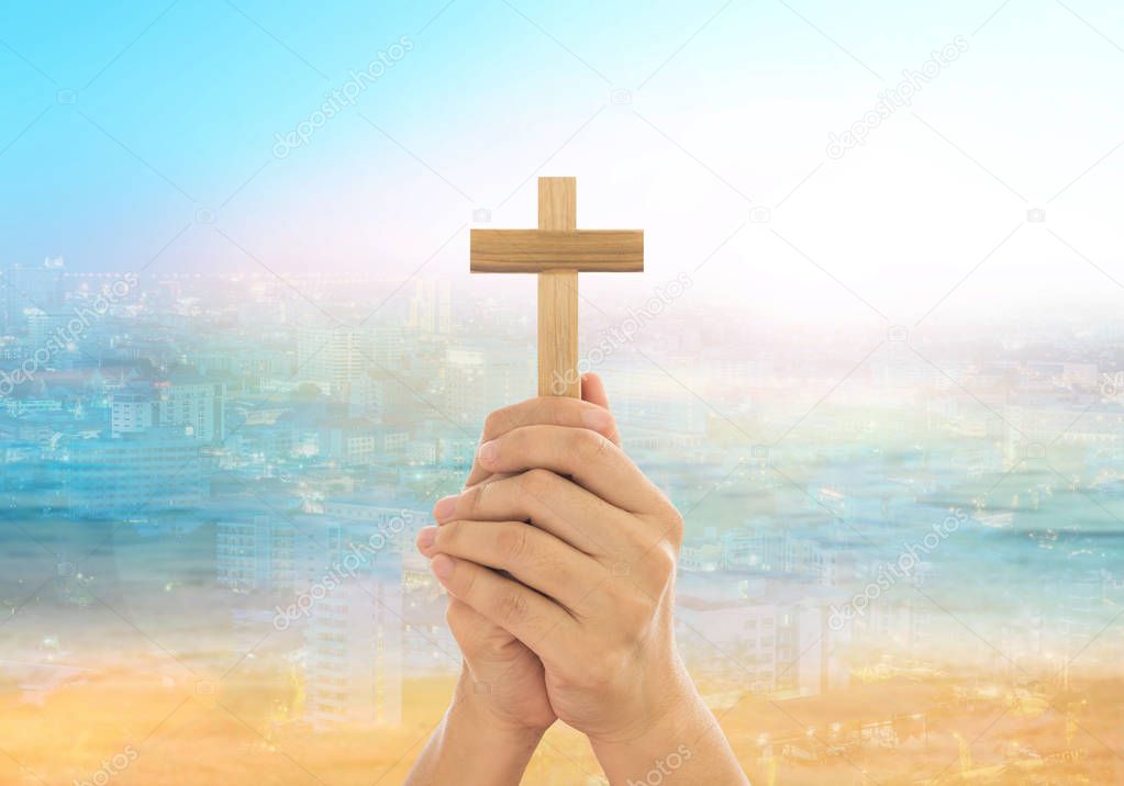 Human hands holding a cross holy and prayed for blessings from God. Amour Worship God concept.