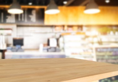 Ahşap masa ve bulanık kafe arka plan boş tepesinde. Ürün görüntülenmek ve reklam ve promosyon amaçlı.