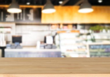 Ahşap masa ve bulanık kafe arka plan boş tepesinde. Ürün görüntülenmek ve reklam ve promosyon amaçlı.