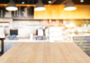 Ahşap masa ve bulanık kafe arka plan boş tepesinde. Ürün görüntülenmek ve reklam ve promosyon amaçlı.