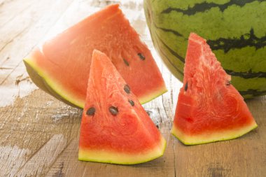 karpuz ve ahşap masa üzerinde olgunlaşmış dilimlenmiş.