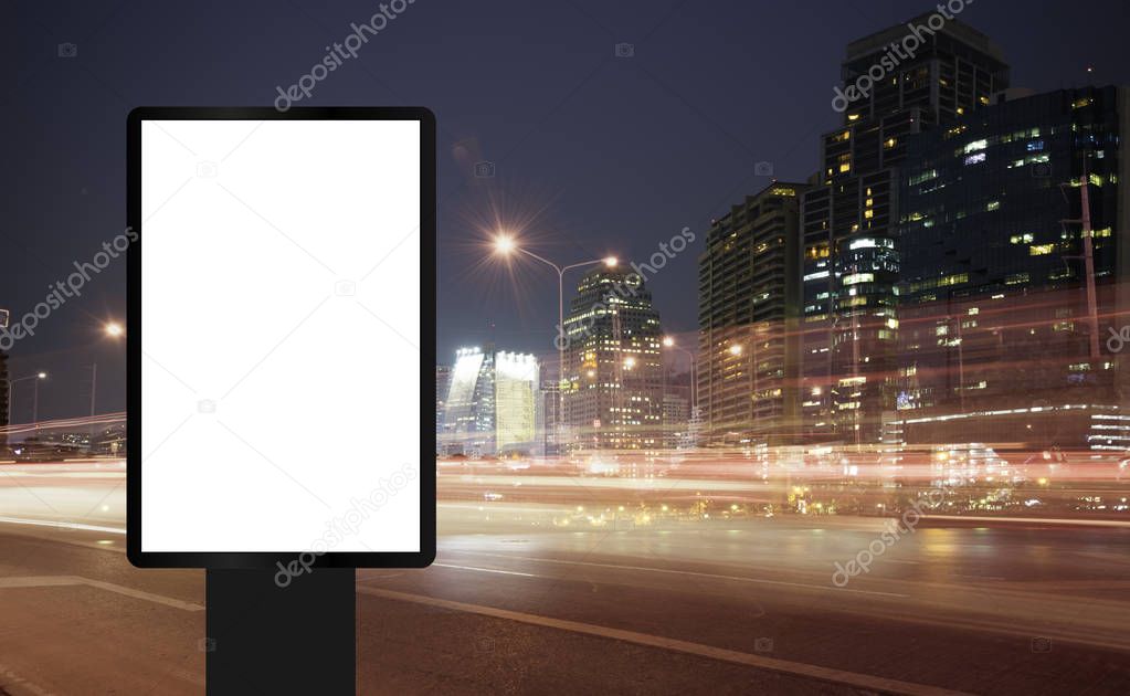 Billboard, banner, empty, white at a bus stop on the highway during the twilight with city background with clipping path on screen.- can be used for display your products or promotional