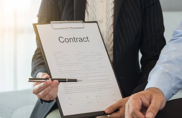 ビジネス女性は契約書に署名するためのパートナーにペンと契約書を送信します — ストック写真