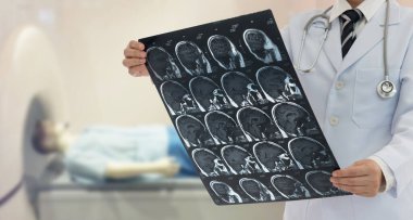 Doktor hastanın MRI taramasıyla beyin röntgenini inceler..