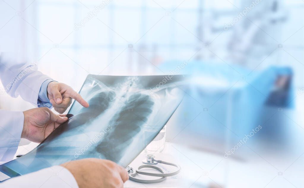 Doctor examining at lungs radiograph x-ray film of patient in operation room.