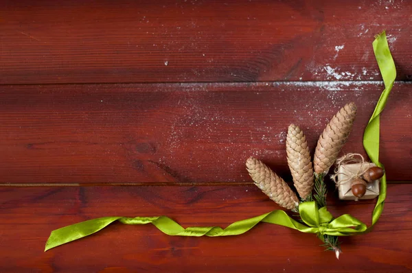 Três pinhas amarradas com fita verde — Fotografia de Stock