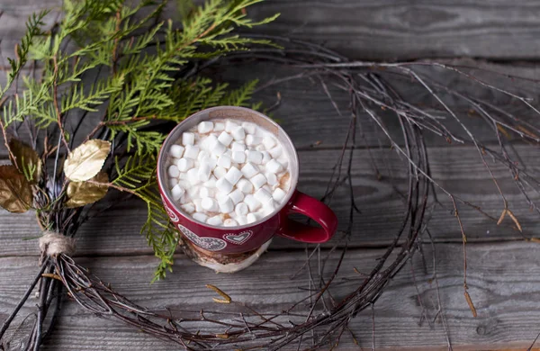 Tasse rouge avec guimauve est encadrée par une couronne de Noël — Photo