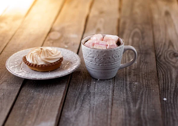 Cesta de bolo com creme em um pires e uma bebida quente — Fotografia de Stock