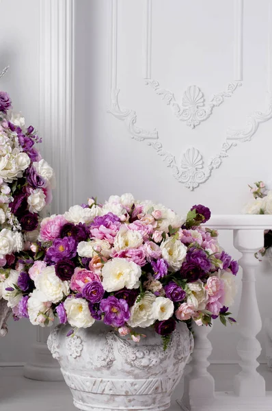 Květináč s růžemi v blízkosti zdi a dekorativní balkon — Stock fotografie