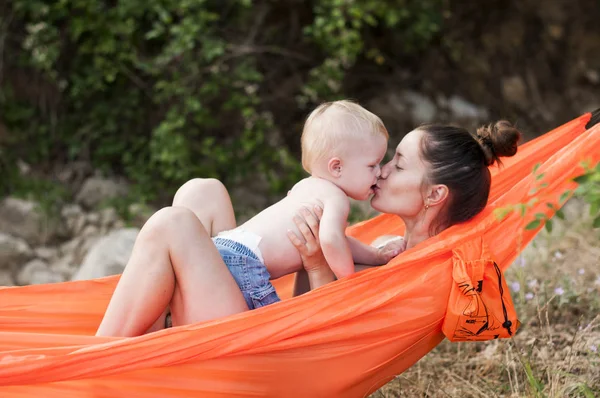 Madre besando a su hijo en una hamaca — Foto de Stock