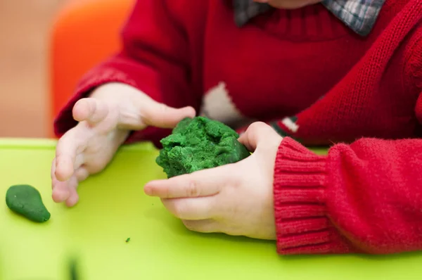 Niño sosteniendo una arcilla verde — Foto de Stock