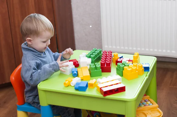 Niño jugando con constructor plástico colorido — Foto de Stock