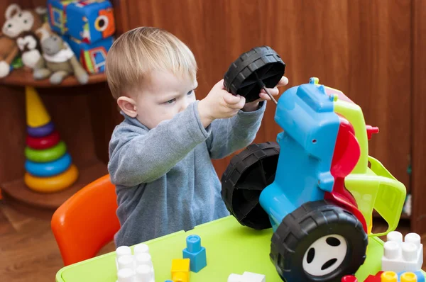 Niño trata de arreglar un tractor de juguete roto — Foto de Stock