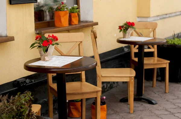 Une terrasse confortable avec une table ronde en bois — Photo