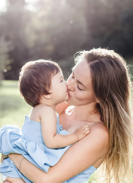 Küçük kızı annesiyle öpüşme güneşli portre — Stok fotoğraf