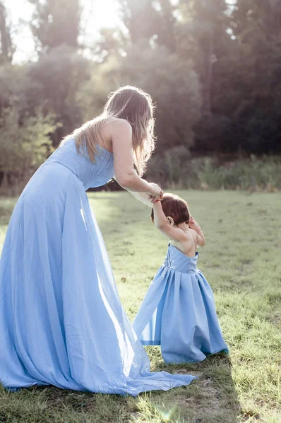 Mamá con hija en azul vestidos largos íntimos — Foto de Stock