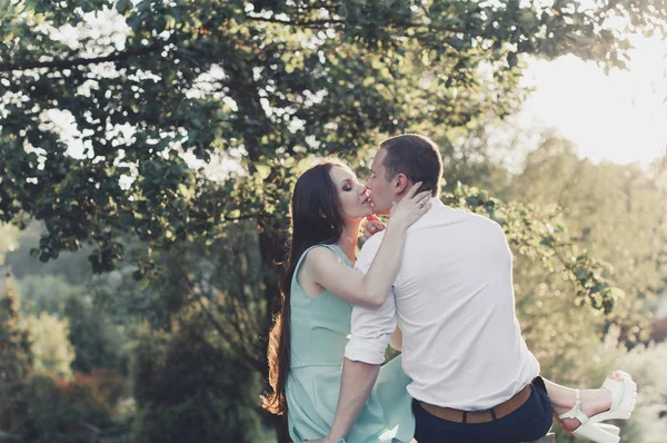 Genç aşıklar öpücük ağaca yakın gün batımında