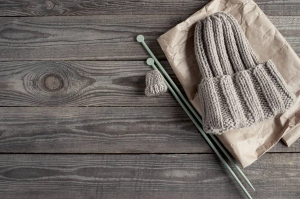 Strickmütze Mit Kleinem Muster Und Nadeln Auf Kraftpapier Und Holzbrett — Stockfoto