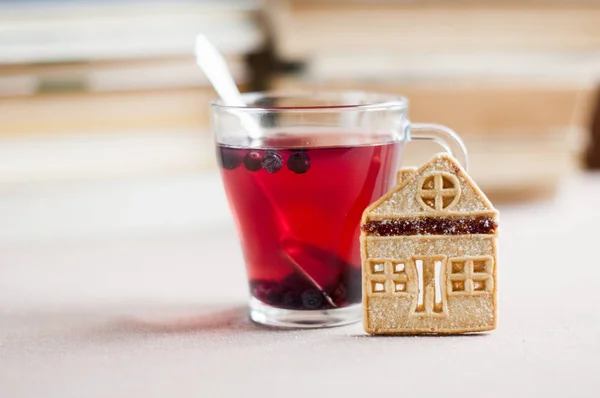 本の背景と家の形のショートブレッド クッキーとガラスのボウルにブルーベリー紅茶 — ストック写真