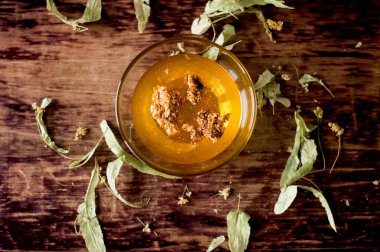 sıvı bal Ihlamur ahşap zemin üzerine bir cam kasede peteğin ile