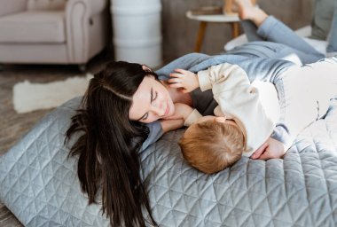 Genç anne küçük oğluyla oynuyor.