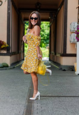 Siyah gözlüklü ve elinde market alışverişi olan mutlu ve çekici bir kız.