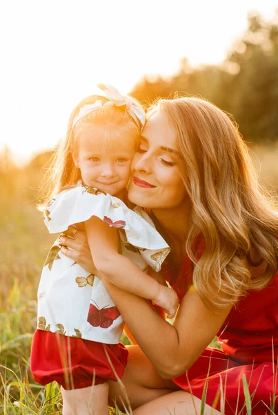 Kırmızı Elbiseli Genç Güzel Anne Tarlada Küçük Bir Kızı Kucaklıyor — Stok fotoğraf