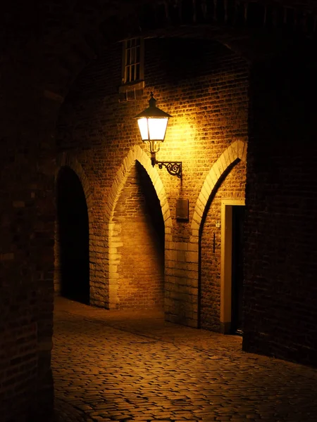 Eski kırmızı tuğla duvar hem ışık duvarda asılı. İyi geceler. Arch. kale