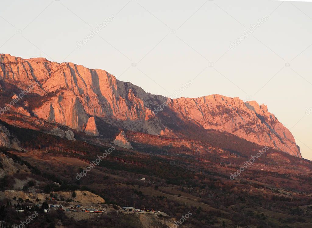 Mountain limestone hills, lit by the setting sun with seagulls below