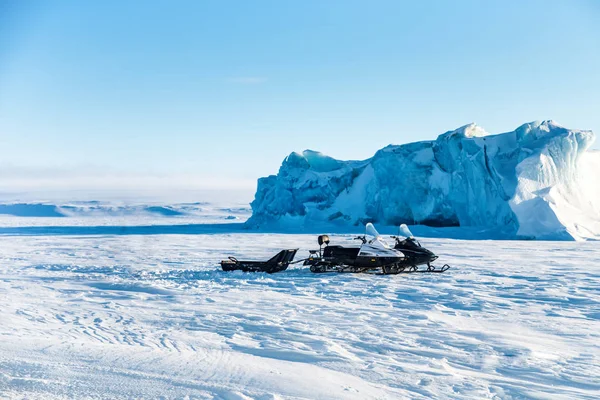 雪の中 台のスノーモービルの氷山近く 北極の風景です 北極海 — ストック写真